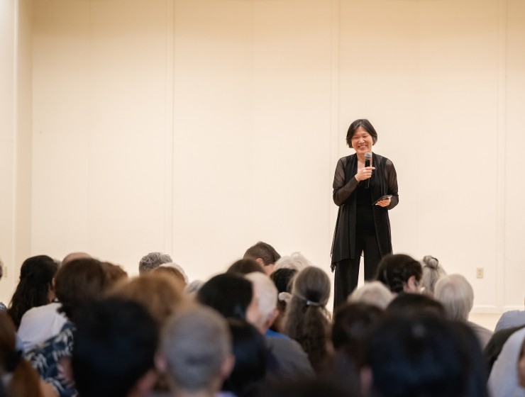 Elizabeth Chang speaking on stage to an audience