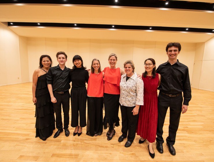a group of fellows and faculty standing on stage after a performance 