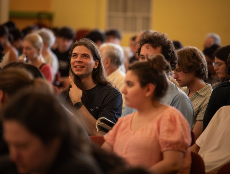 a photo of a concert audience focused on a singular student who is looking up and smiling