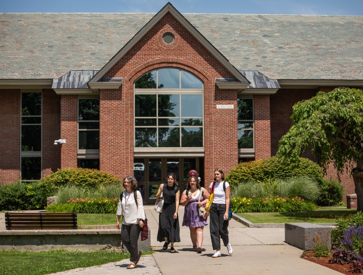 students leaving a building with instruments on their back