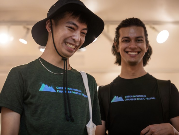 two students wearing t-shirts that show the Green Mountain Chamber Music Festival logo and smiling cheekily