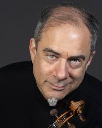 A man wearing a dark shirt holding a violin