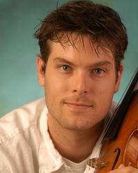 A headshot of a man with the violin close to his head on the right
