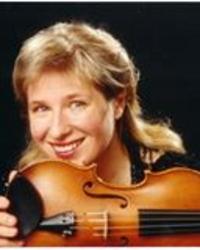 A woman smiling and holding a violin horizontally in front of her face