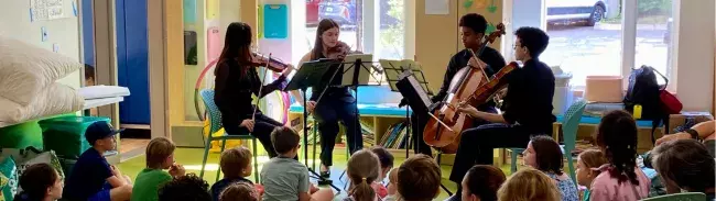 students performing for a group of kids