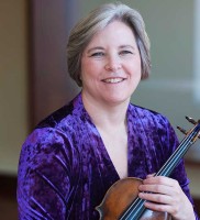 A woman in a purple velvet shirt holding a violin