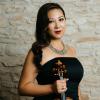 A woman wearing a black dress holding a violin